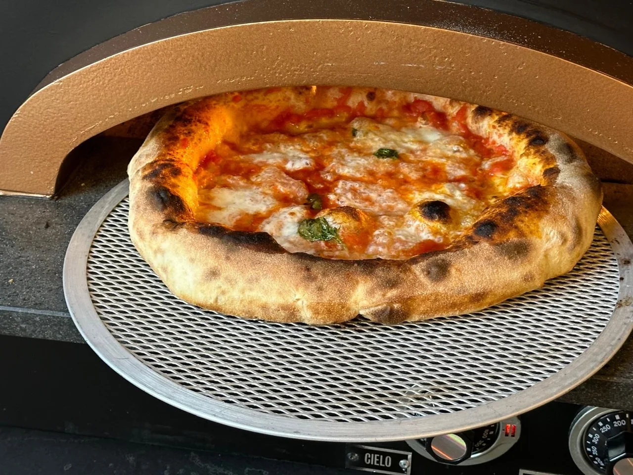 Una pizza rossa cuoce nel forno durante il corso.